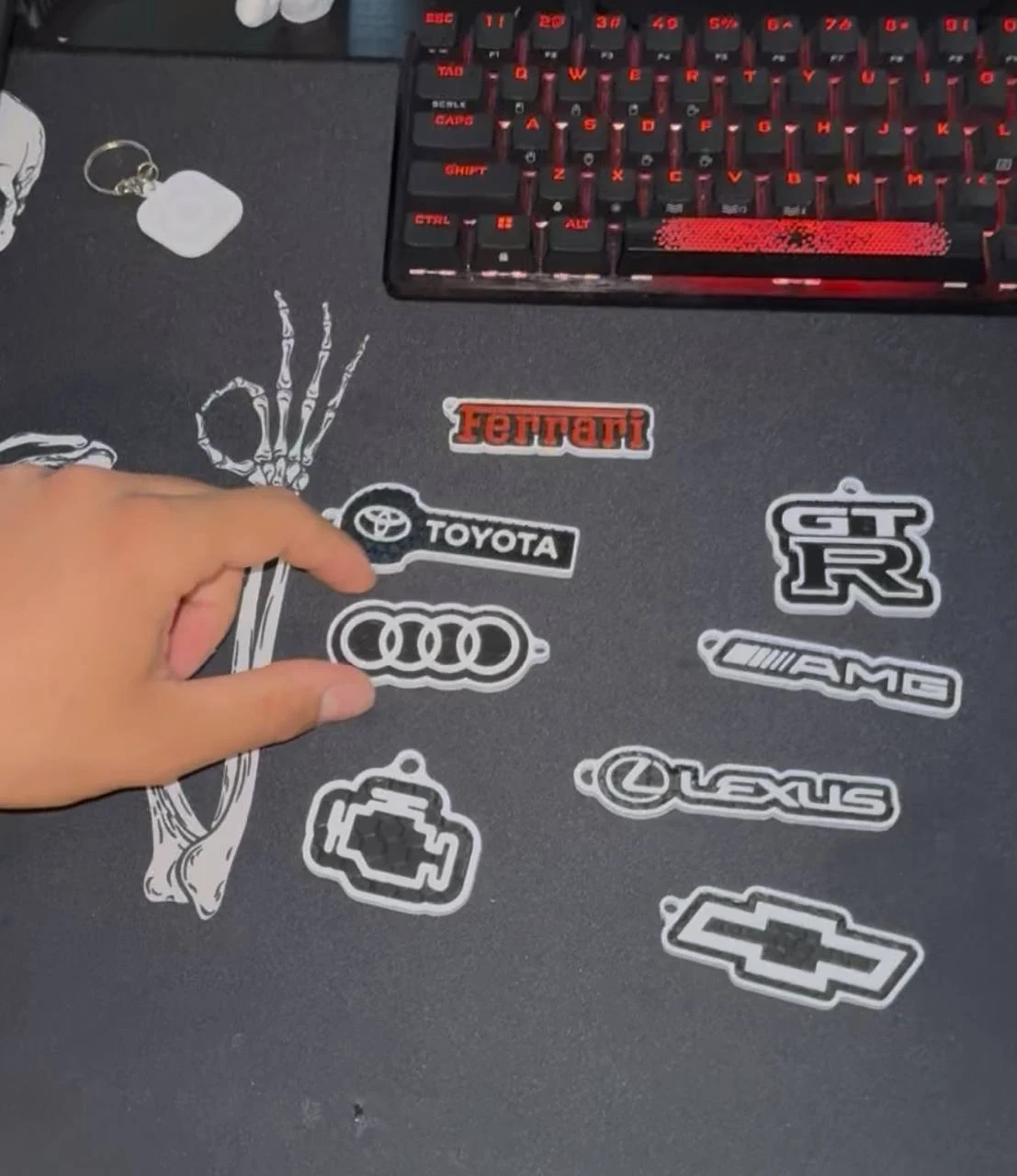 A collection of custom automotive logo and engine-shaped keychain pieces